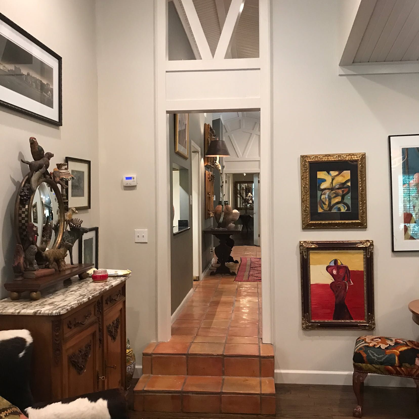 A living room with pictures on the wall and a doorway