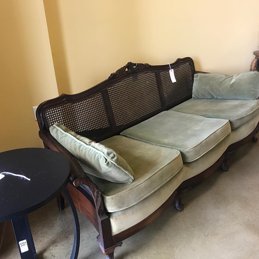 A couch is sitting next to a table in a room.
