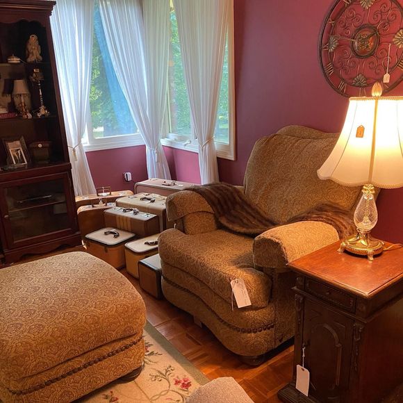 A living room with a chair ottoman and lamp