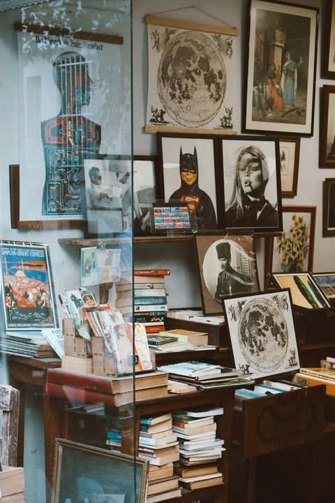 A room filled with lots of pictures and books on a table.