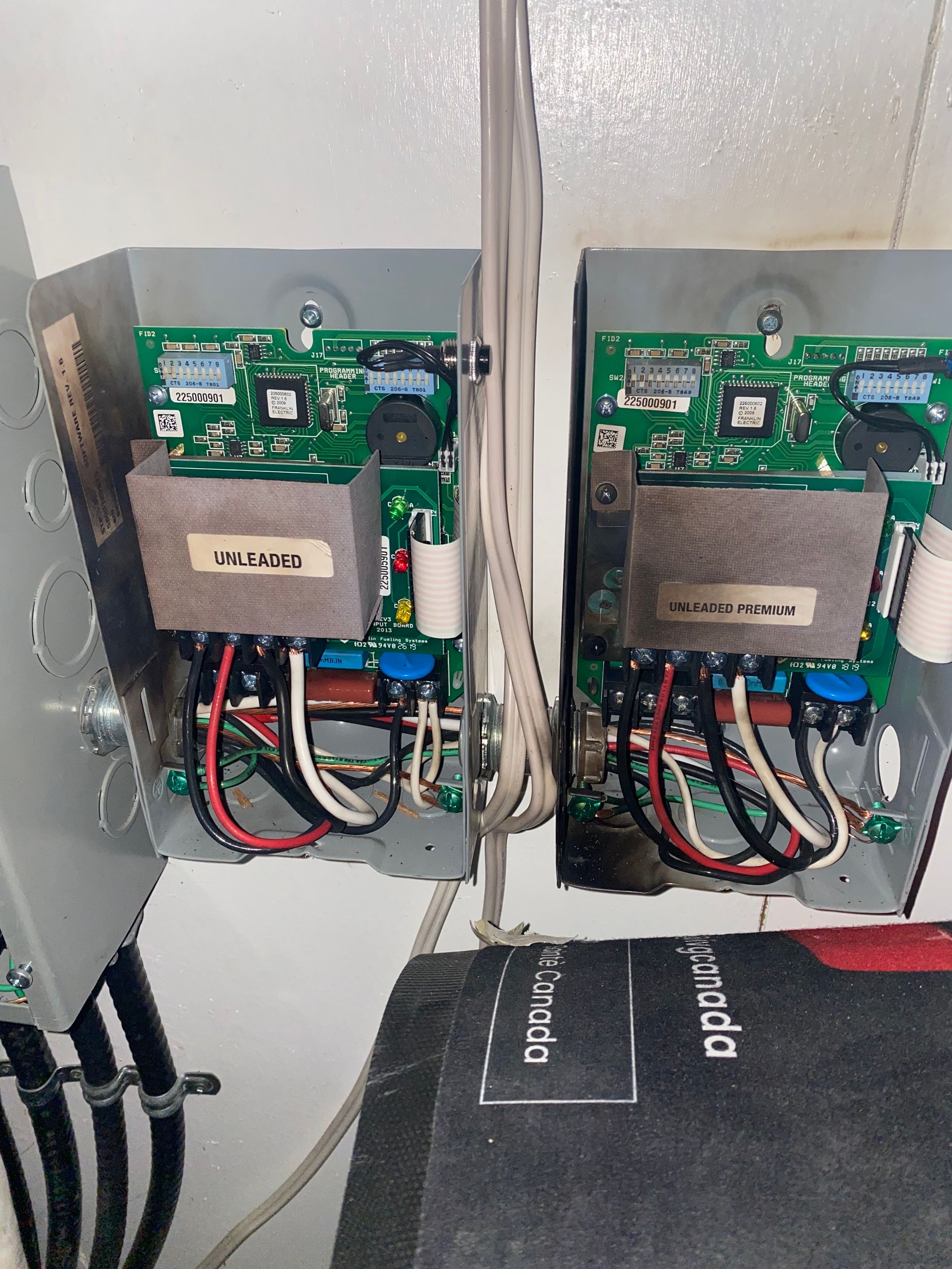 Two electrical control boxes with circuit boards, wires, and transformers, mounted on a wall.