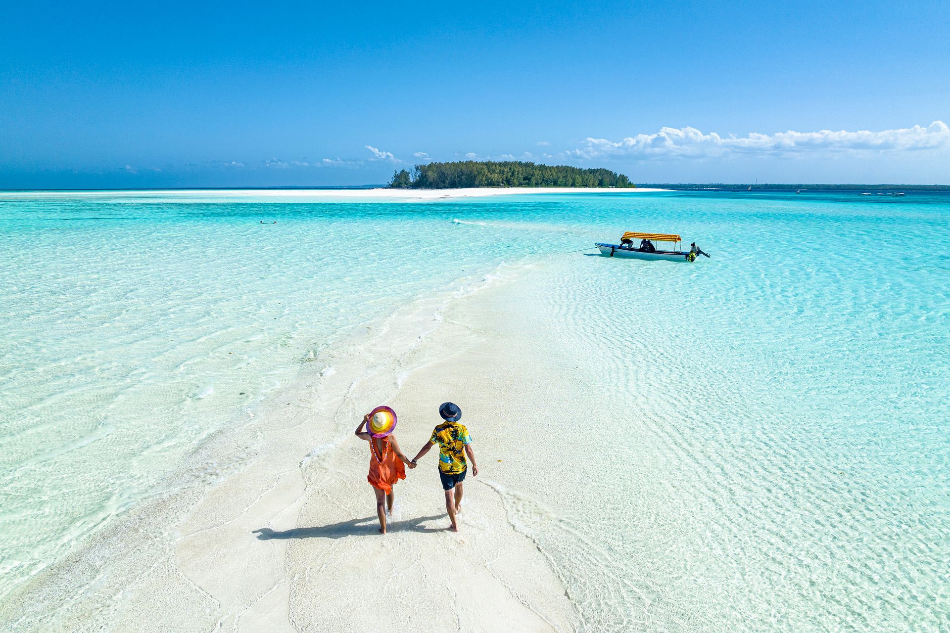 A woman in a life jacket is pointing at something while sitting on a boat.