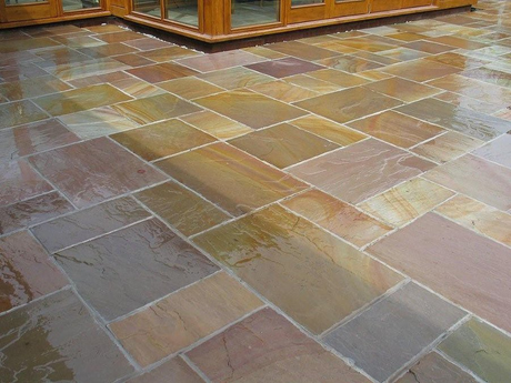 Geometric tile flooring outdoors with tree and building