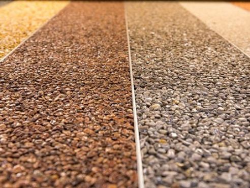 Close up of a natural stone carpet. Decorative stone coating. Slip resistant floor finish containing natural stone particles. Set of various types and colors