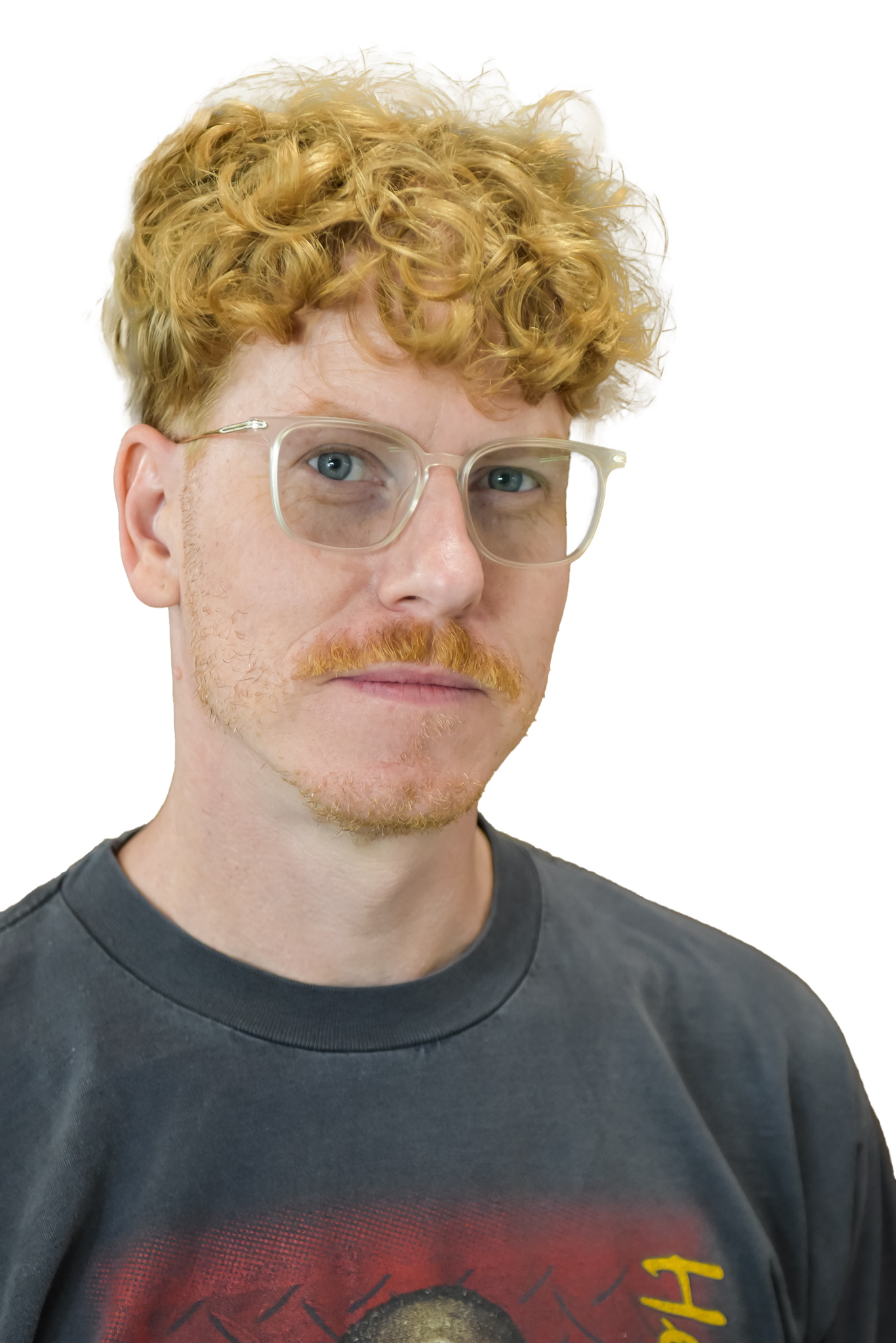 Man with red curly hair and glasses, wearing a gray t-shirt.