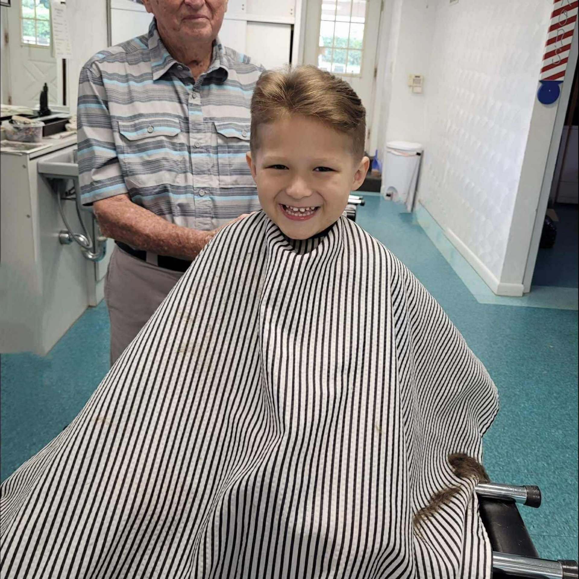 Barber shaving a man's neck and beard with a straight razor; close-up.