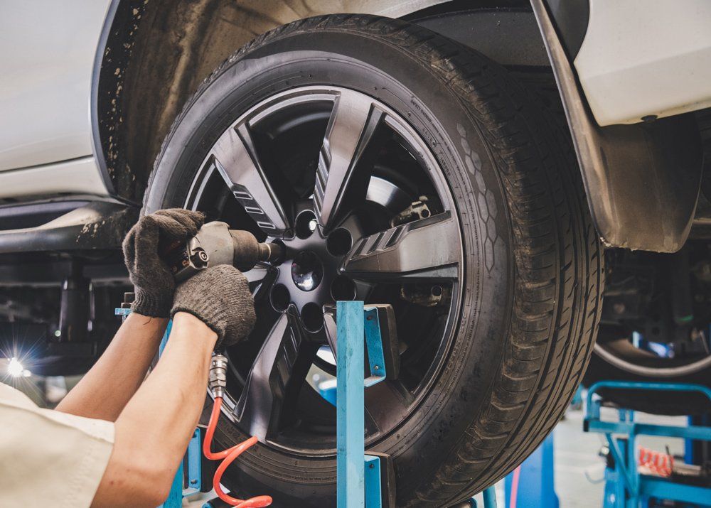 Car Mechanic Is Changing the Tire — Butler, PA — West End Tire & Service