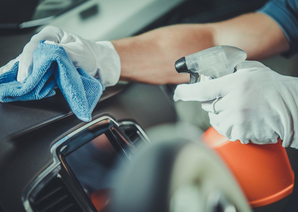 Worker Cleaning Car Dashboard — Butler, PA — West End Tire & Service