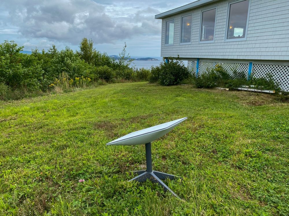 Small White Satellite Dish on a Tripod in a Grassy Yard — PowerMaster Batteries Moree in St, Moree, NSW
