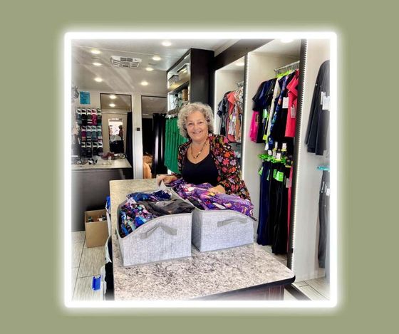 A woman is standing at a counter in a clothing store.