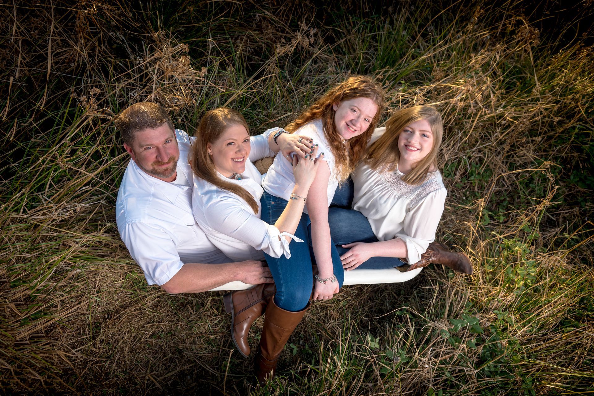 A family is posing for a picture in a field.