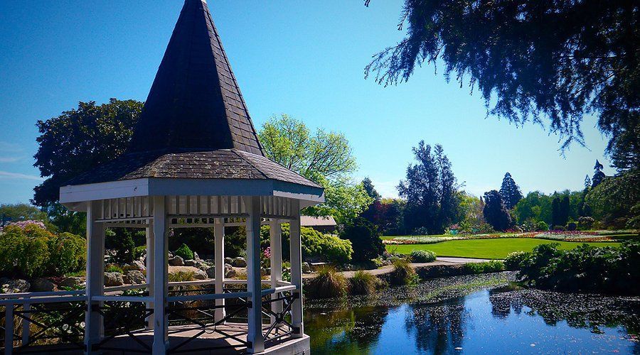 A gazebo in a park with a pond in the background