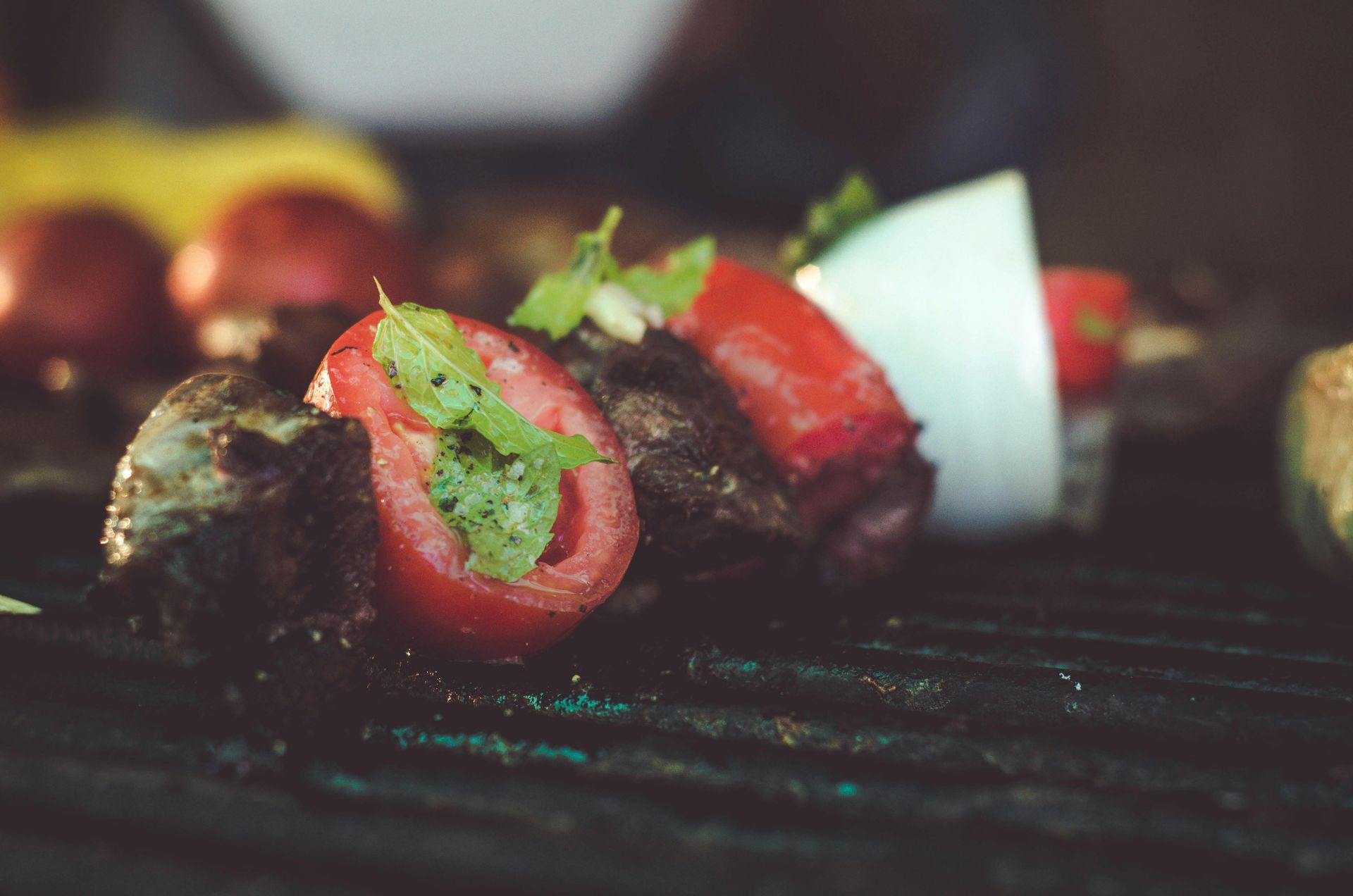 A close up of a grill with meat and vegetables on it.