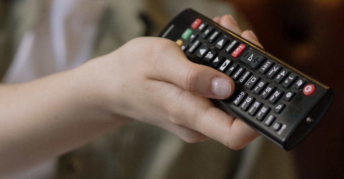 A person is holding a remote control in their hand.