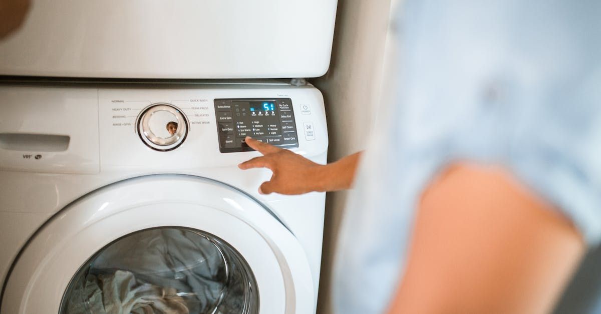 A person is pressing a button on a washing machine.