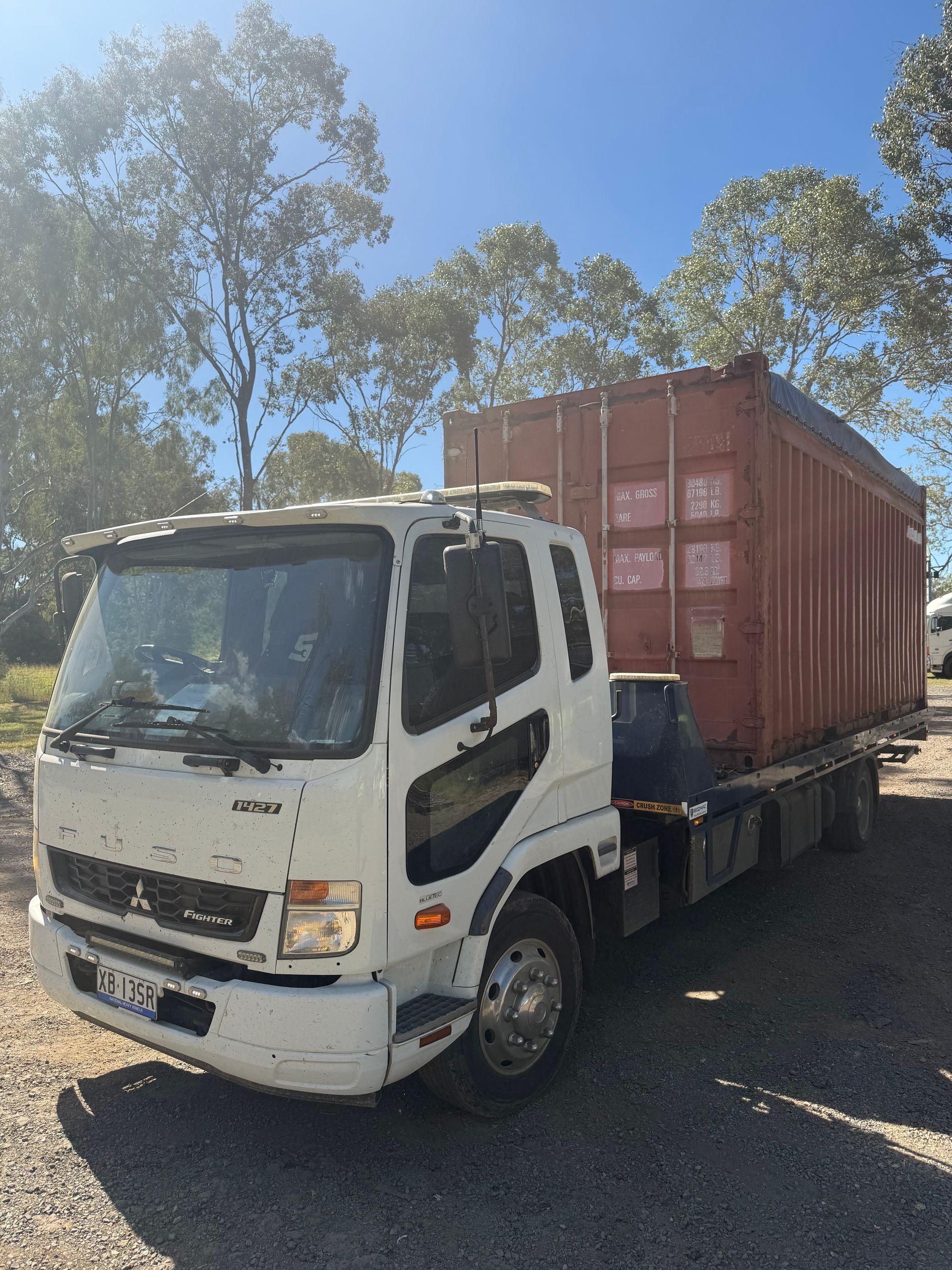 A Red And White Trailer Is Being Towed By A Tow Truck — Rockhampton Towing And Transport in Gracemere, QLD
