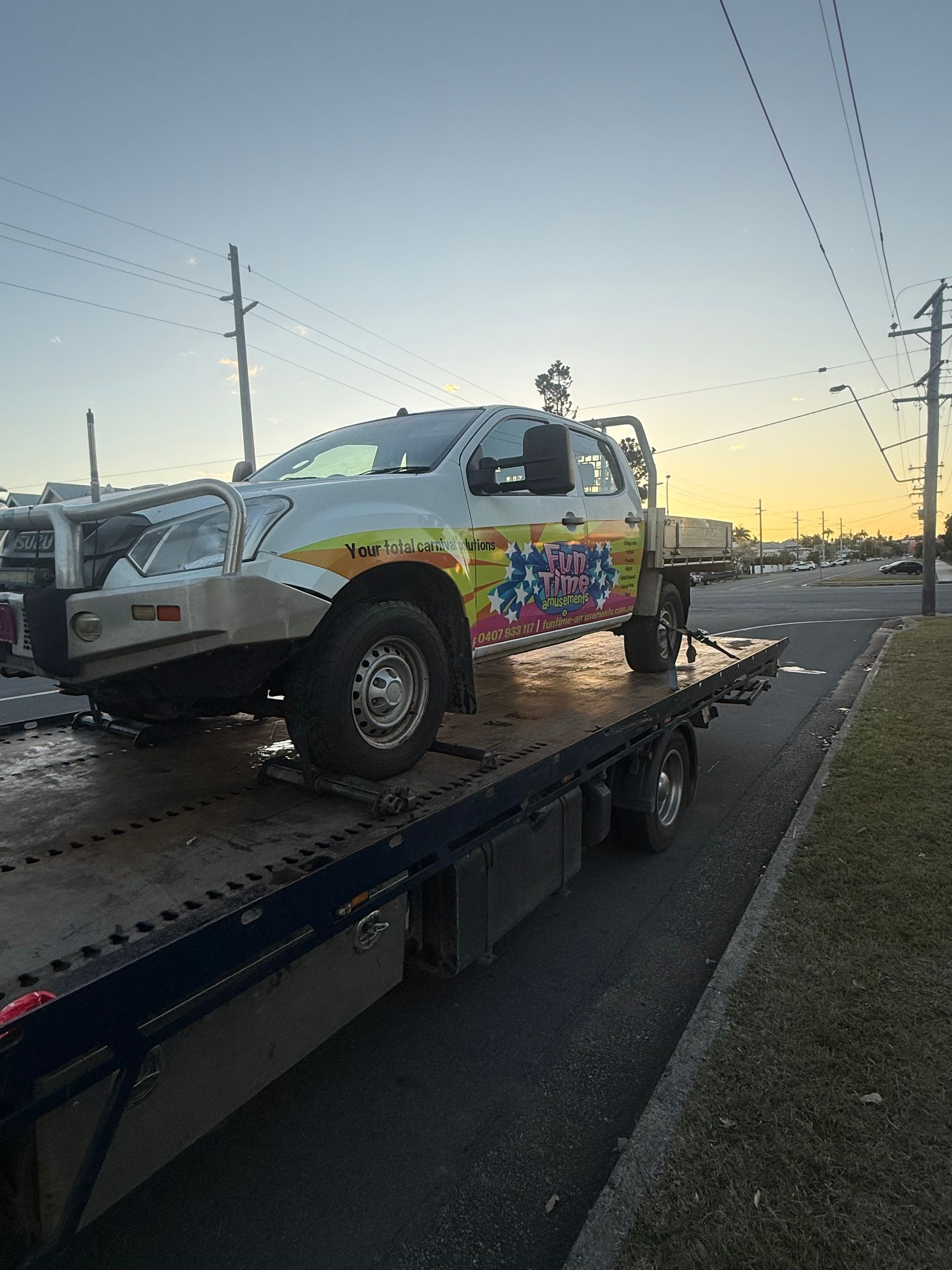 A Red Car Is Being Towed By A Tow Truck — Rockhampton Towing And Transport in Gracemere, QLD