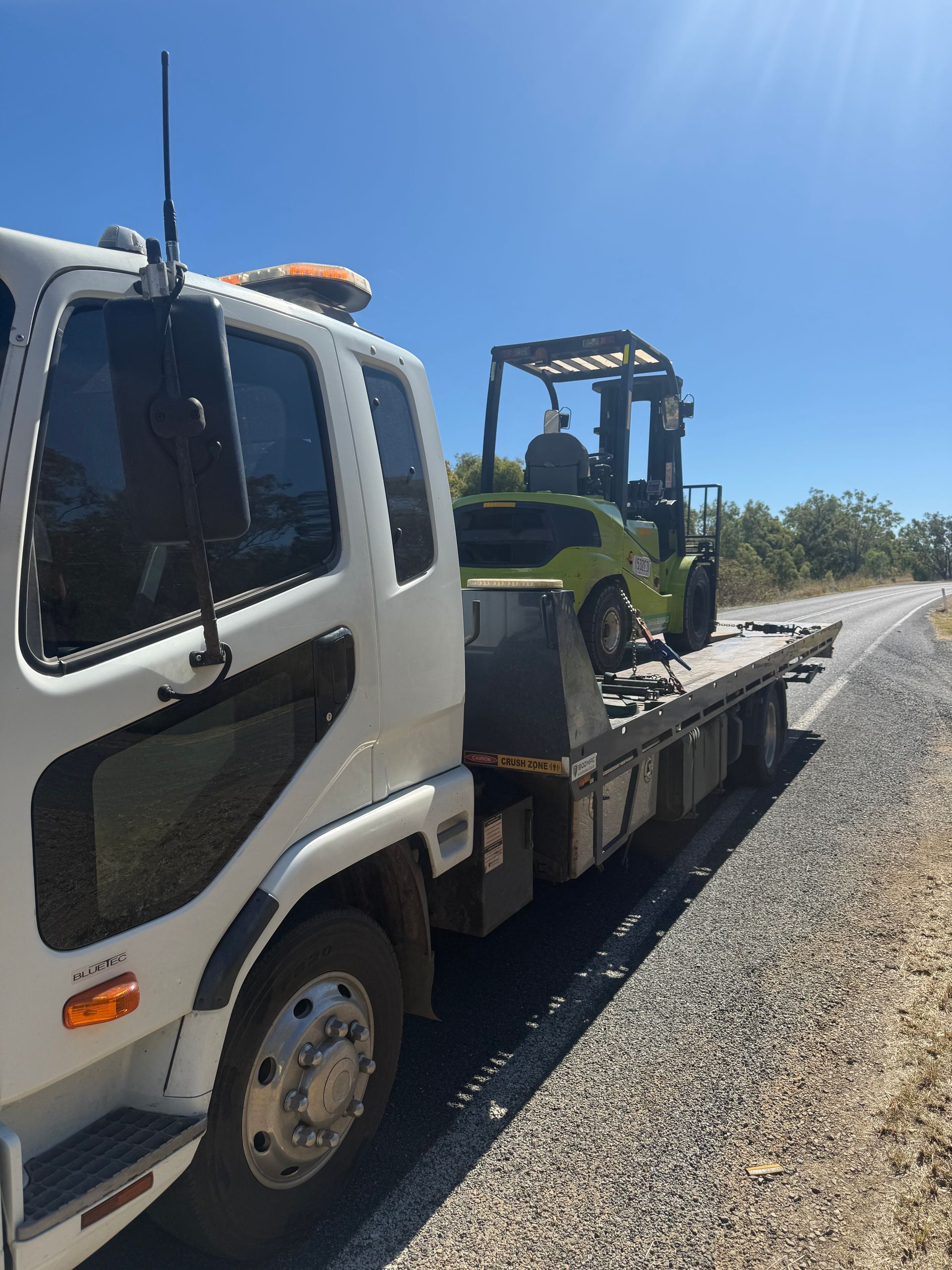 A White Truck With A Yellow Container On The Back Is Parked In A Field — Rockhampton Towing And Transport in Gracemere, QLD