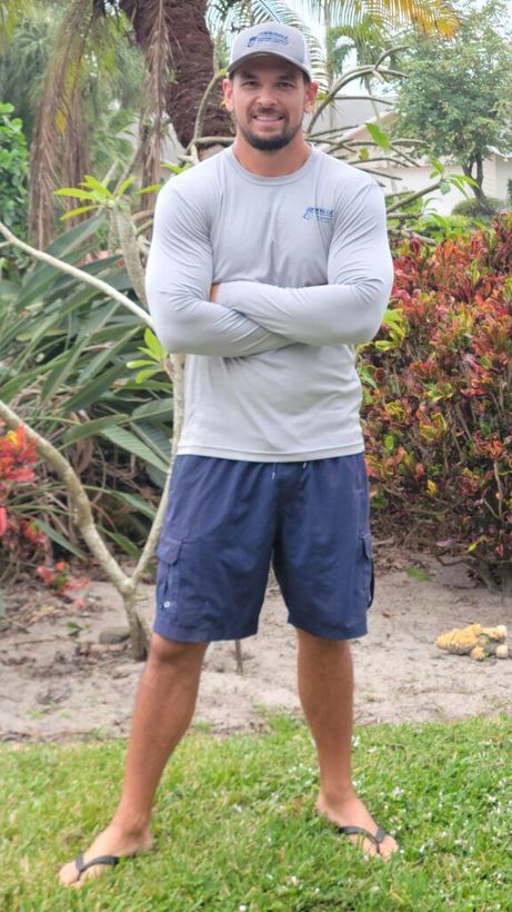 Man with crossed arms wearing a grey long-sleeved shirt