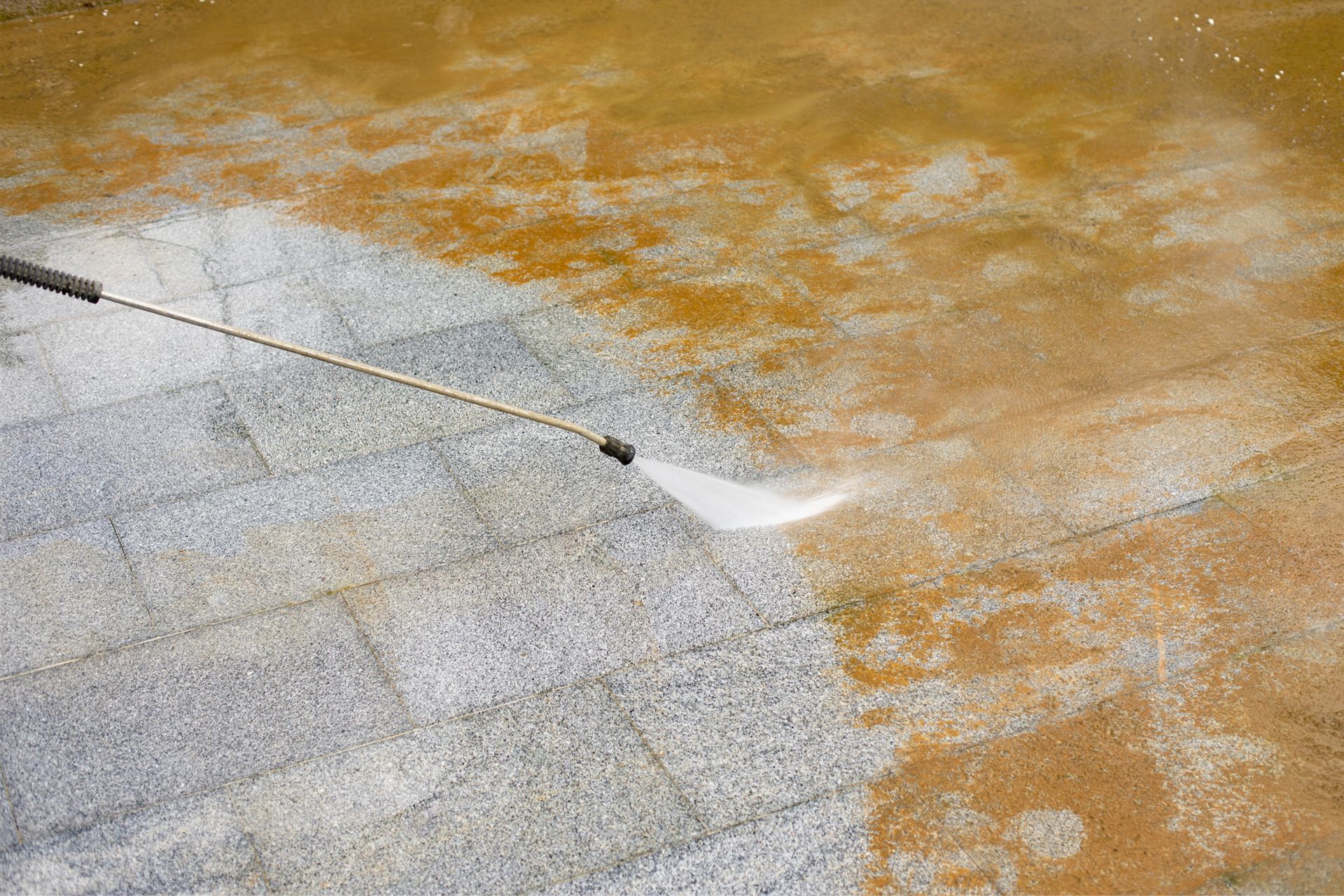 Power washer cleaning a stone patio, removing dirt and revealing clean surface. Power washer cleaning a stone patio, removing dirt and revealing clean surface.
