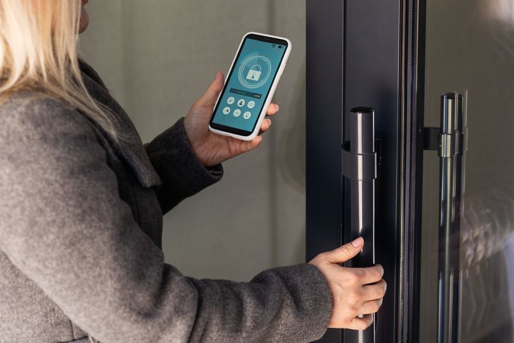 A woman is using a smart phone to open a door.