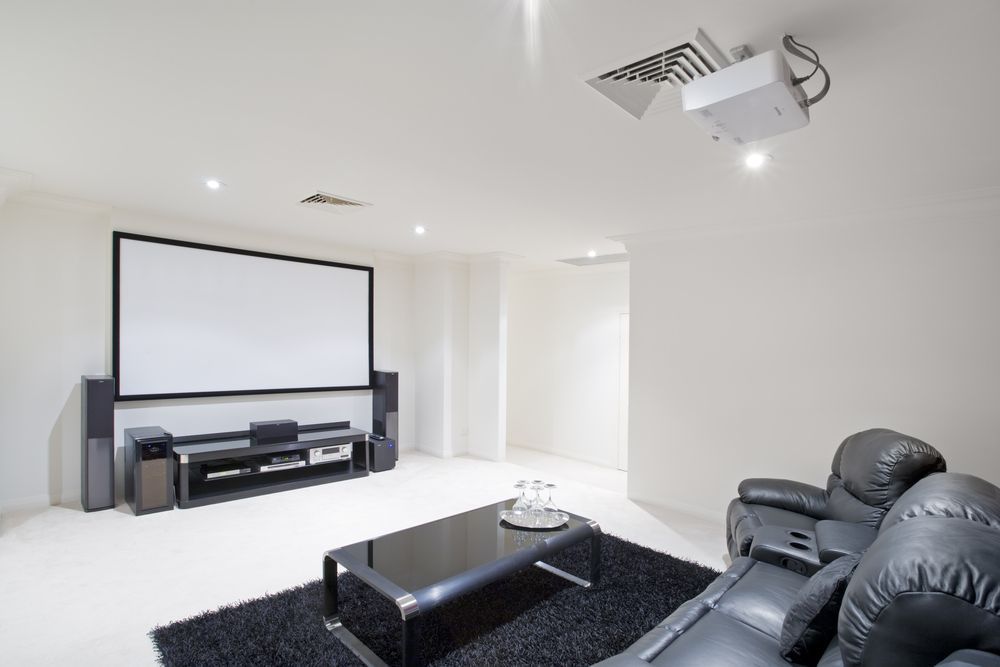 A living room with a projector screen and a couch.