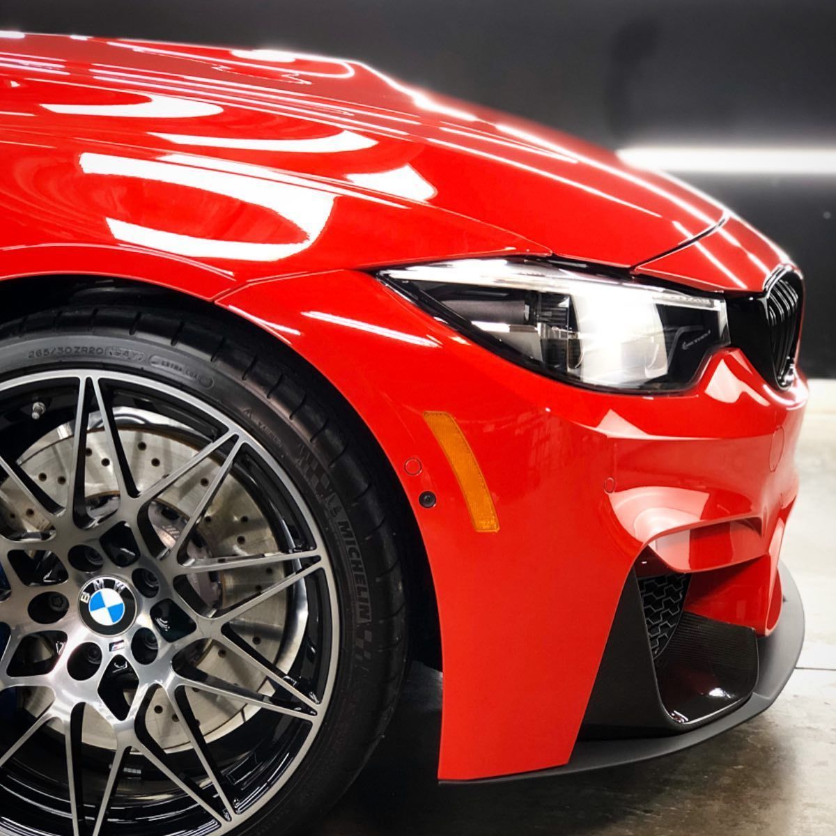 A red car with a bmw logo on the wheel