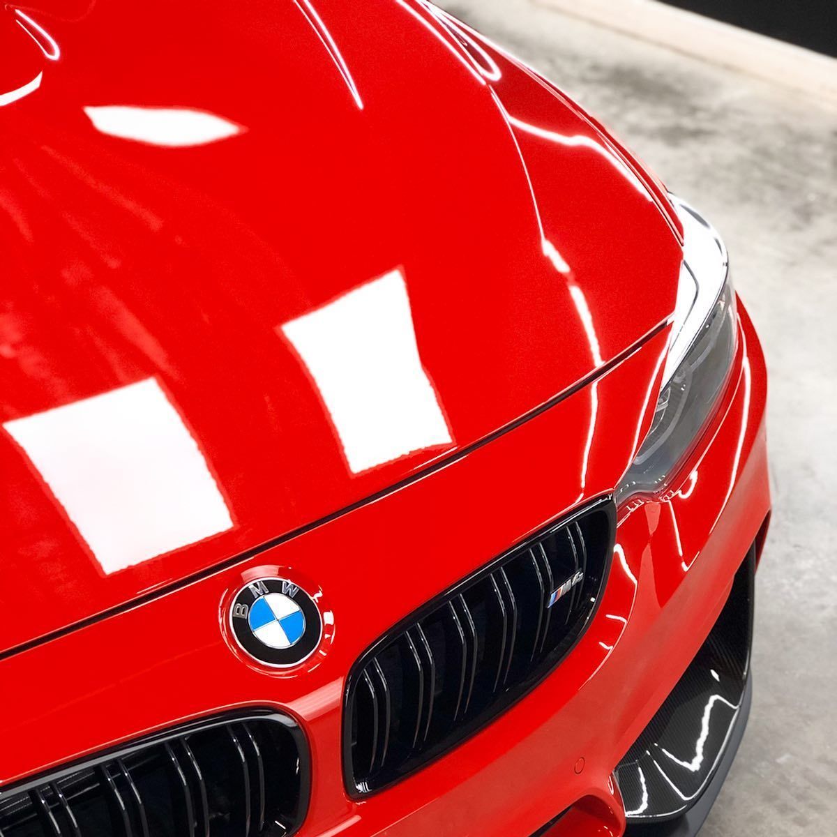 A close up of a red bmw with the hood open