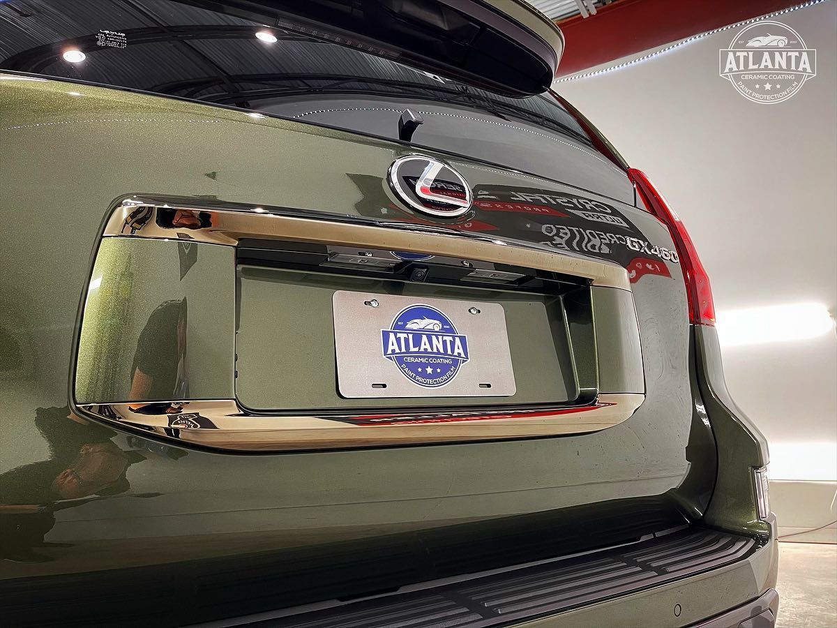 Rear view of a green Lexus GX with a chrome license plate frame and Atlanta license plate.