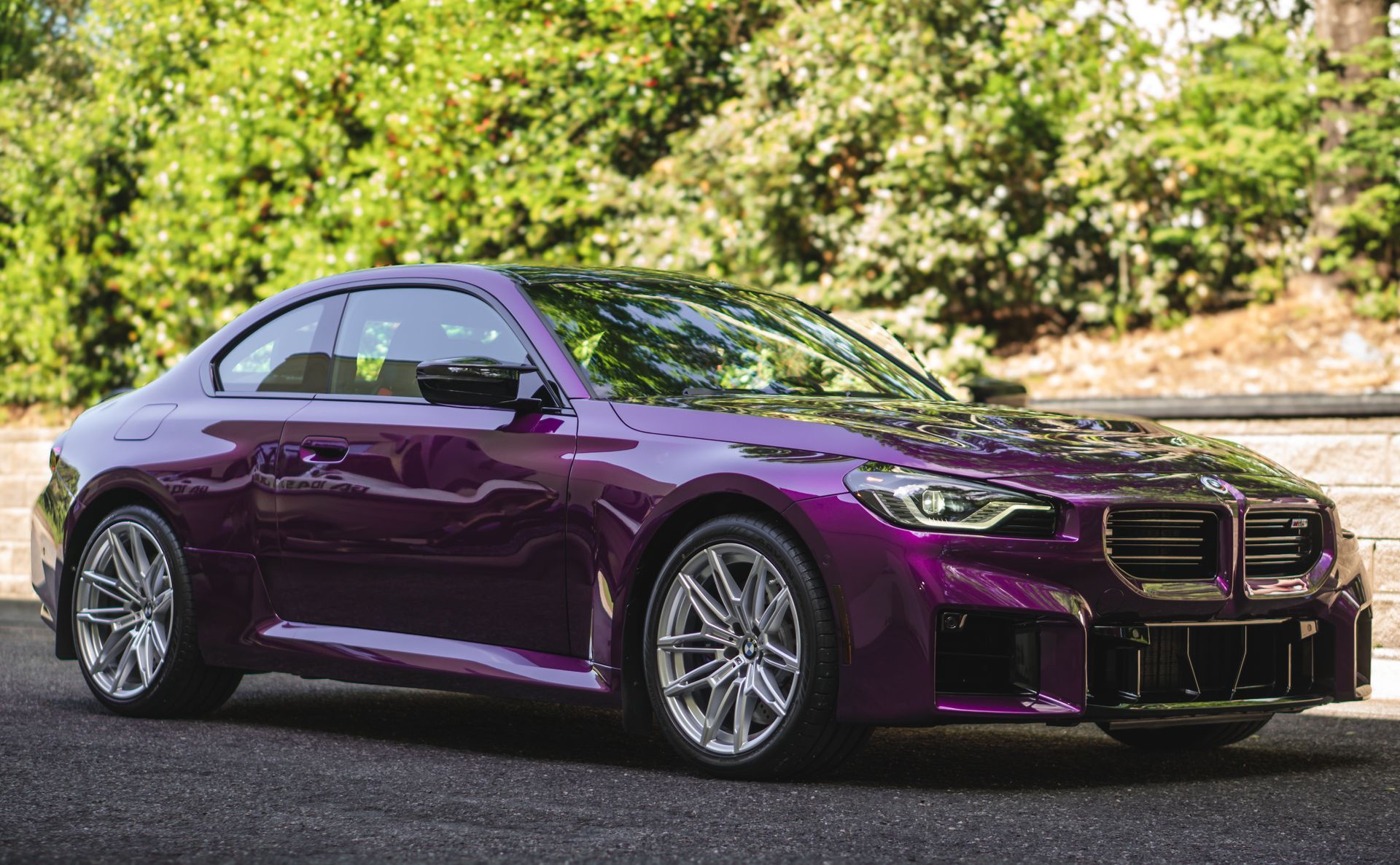 A purple bmw m4 is parked on the side of the road.
