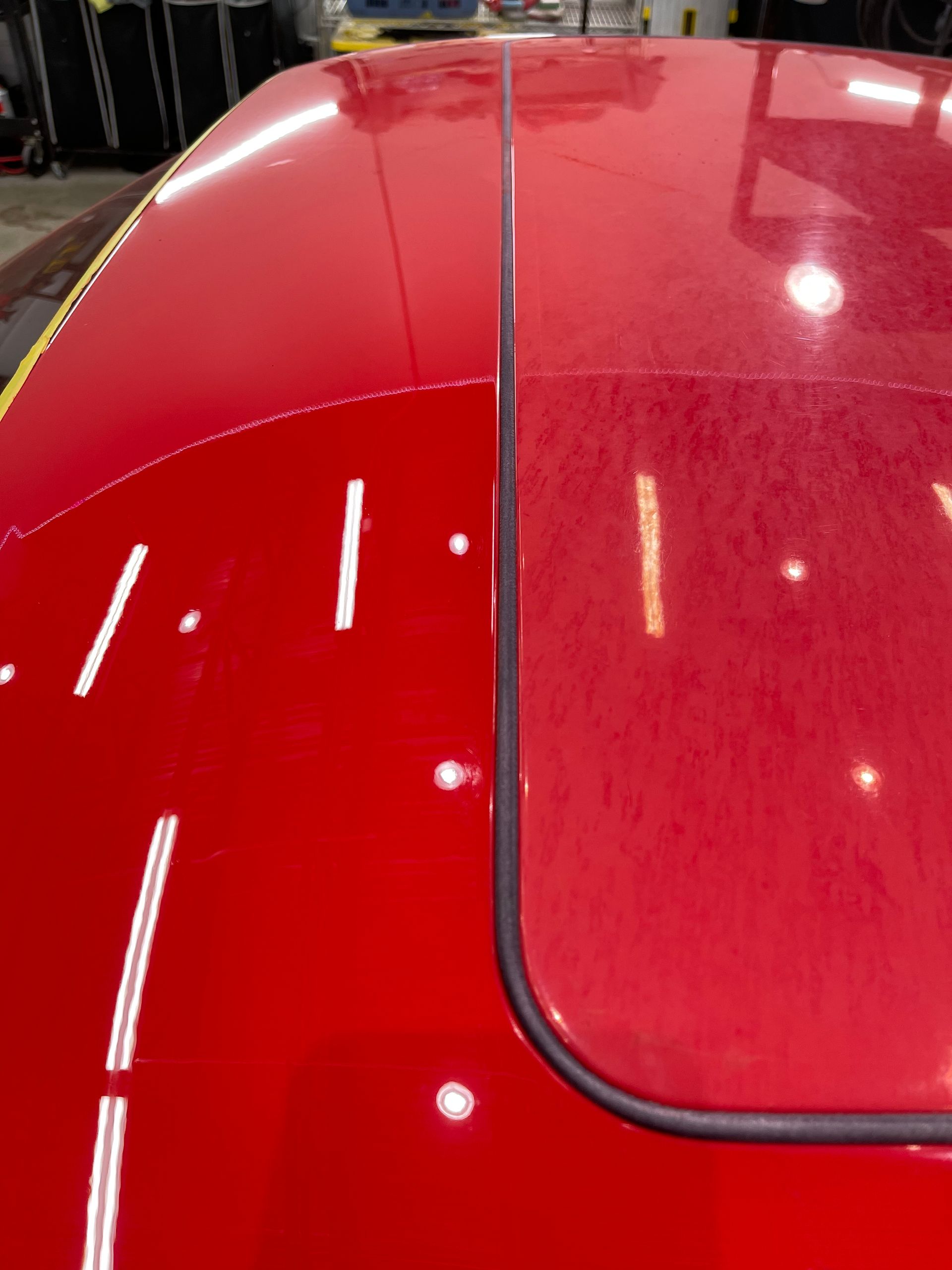 A close up of a red car 's roof in a garage