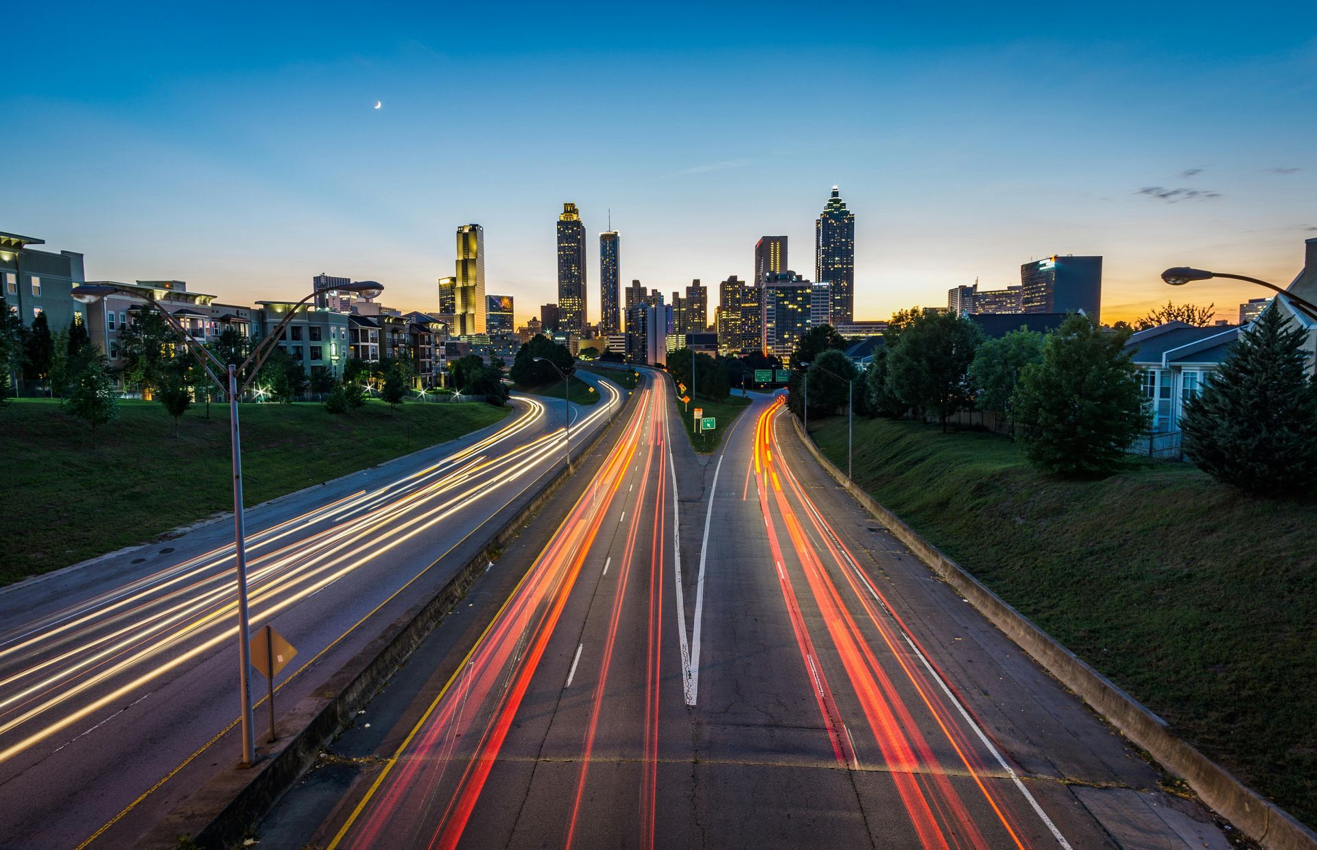 A long exposure photo of a highway at night with a city skyline in the background.