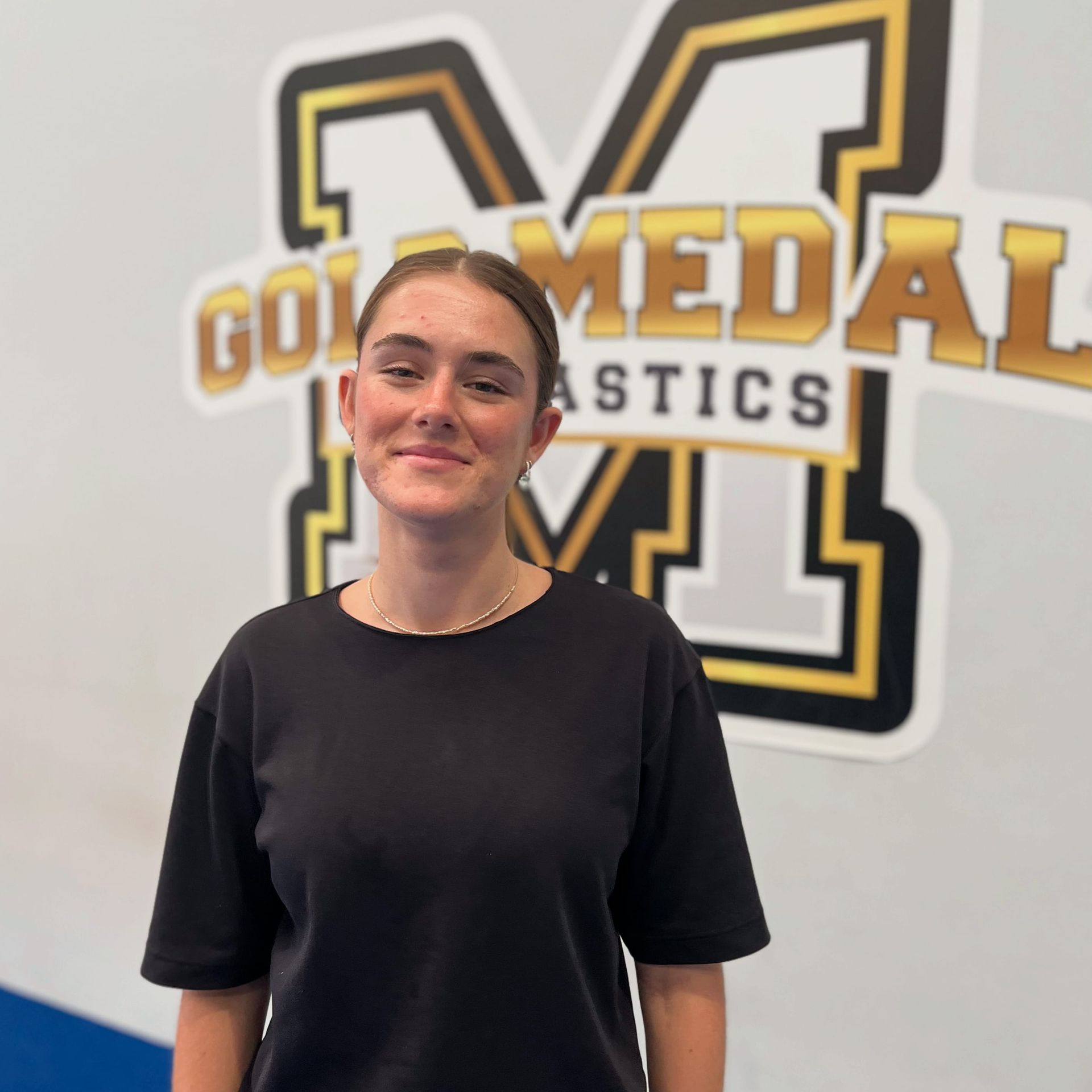 Woman in black shirt smiles in front of 