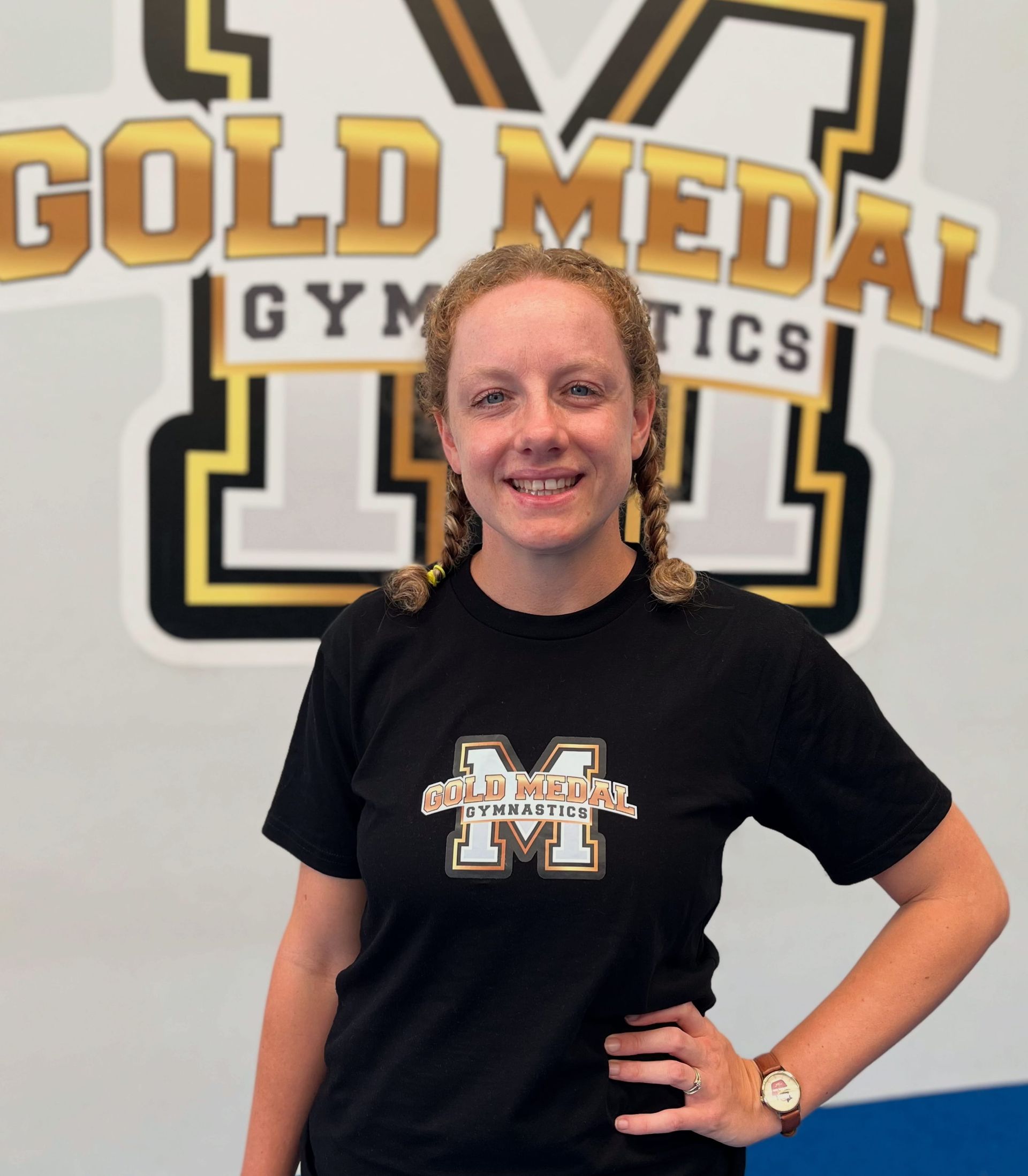 Woman in black shirt with braids in front of 