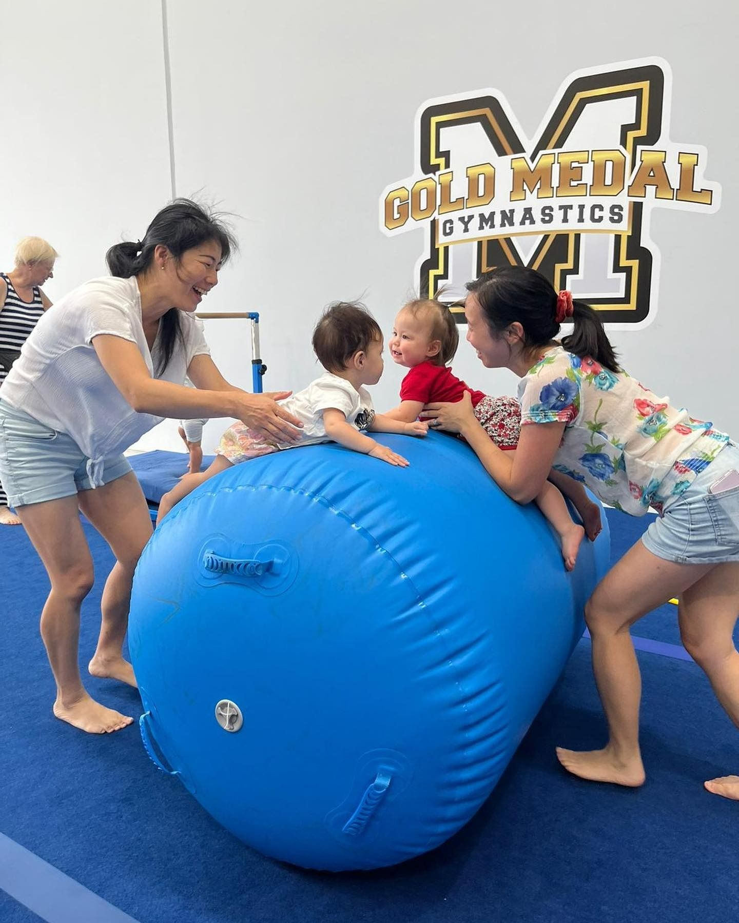 A Group Of People Are Playing With A Large Blue Ball — Gold Medal Gymnastics In Molendinar, QLD