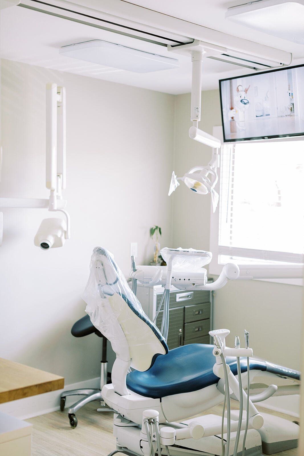 A dental office with a dental chair and a television.
