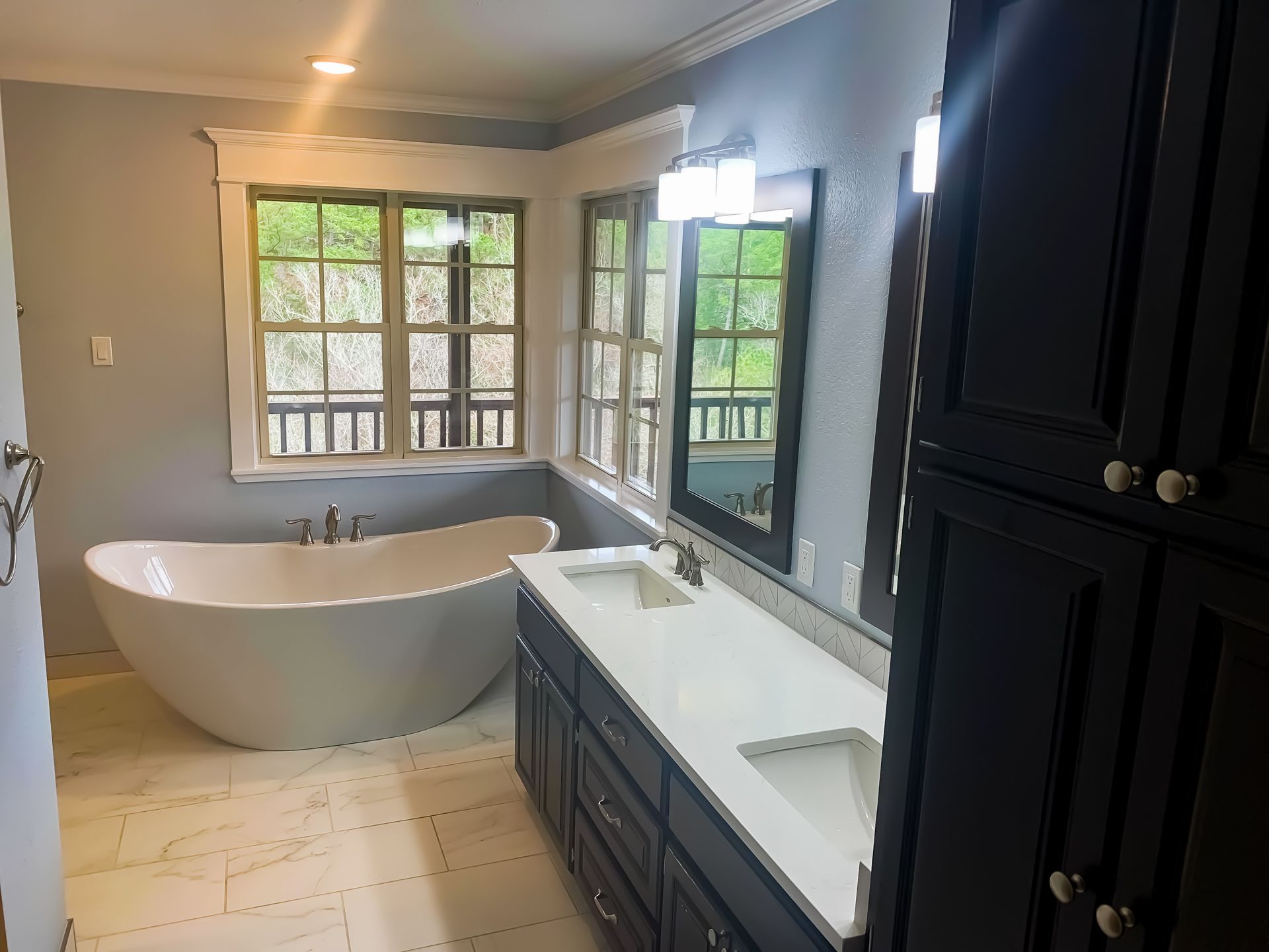A bathroom with a tub , sink and mirror.