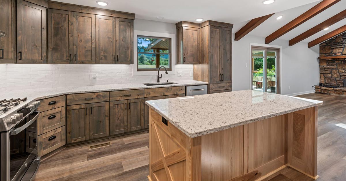 A kitchen with wooden cabinets , granite counter tops , stainless steel appliances and a large island.