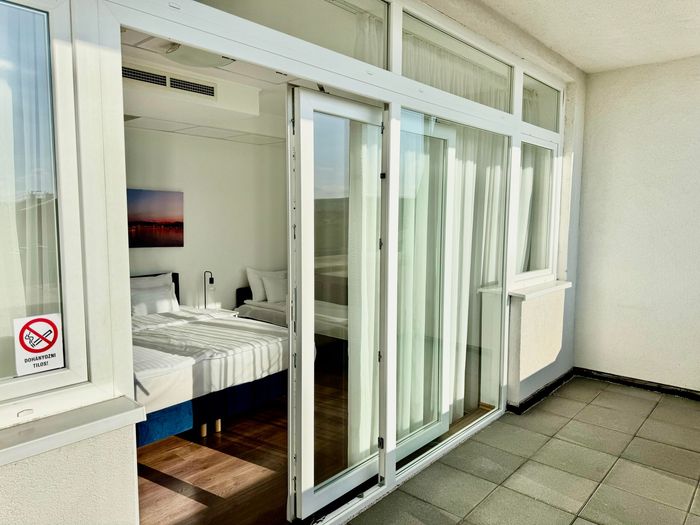 A hotel room with two beds and a couch.