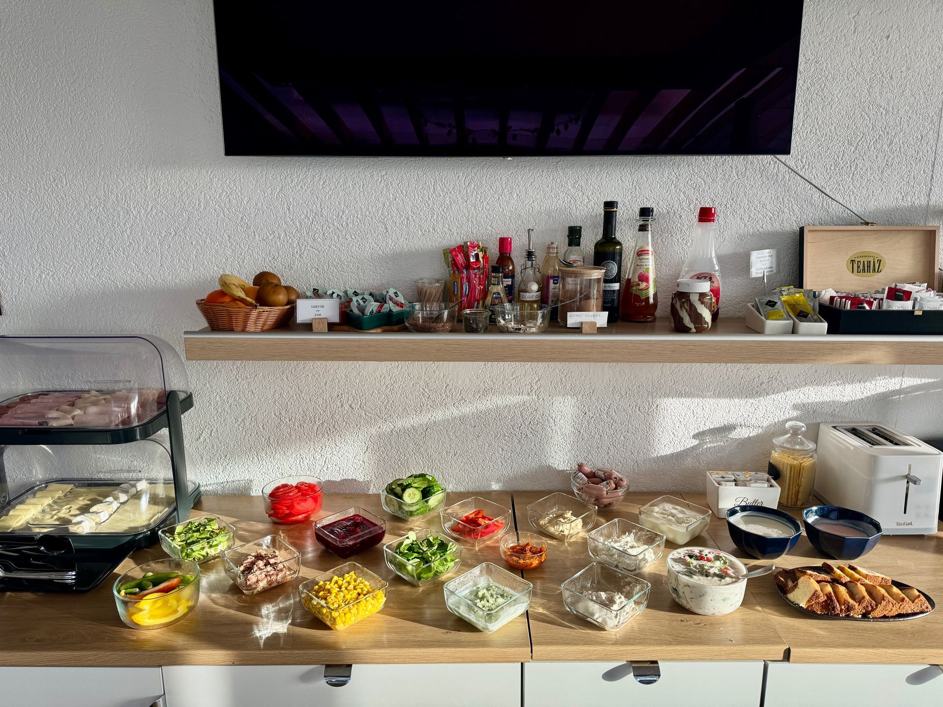 Breakfast buffet with various food items on a counter and shelf.