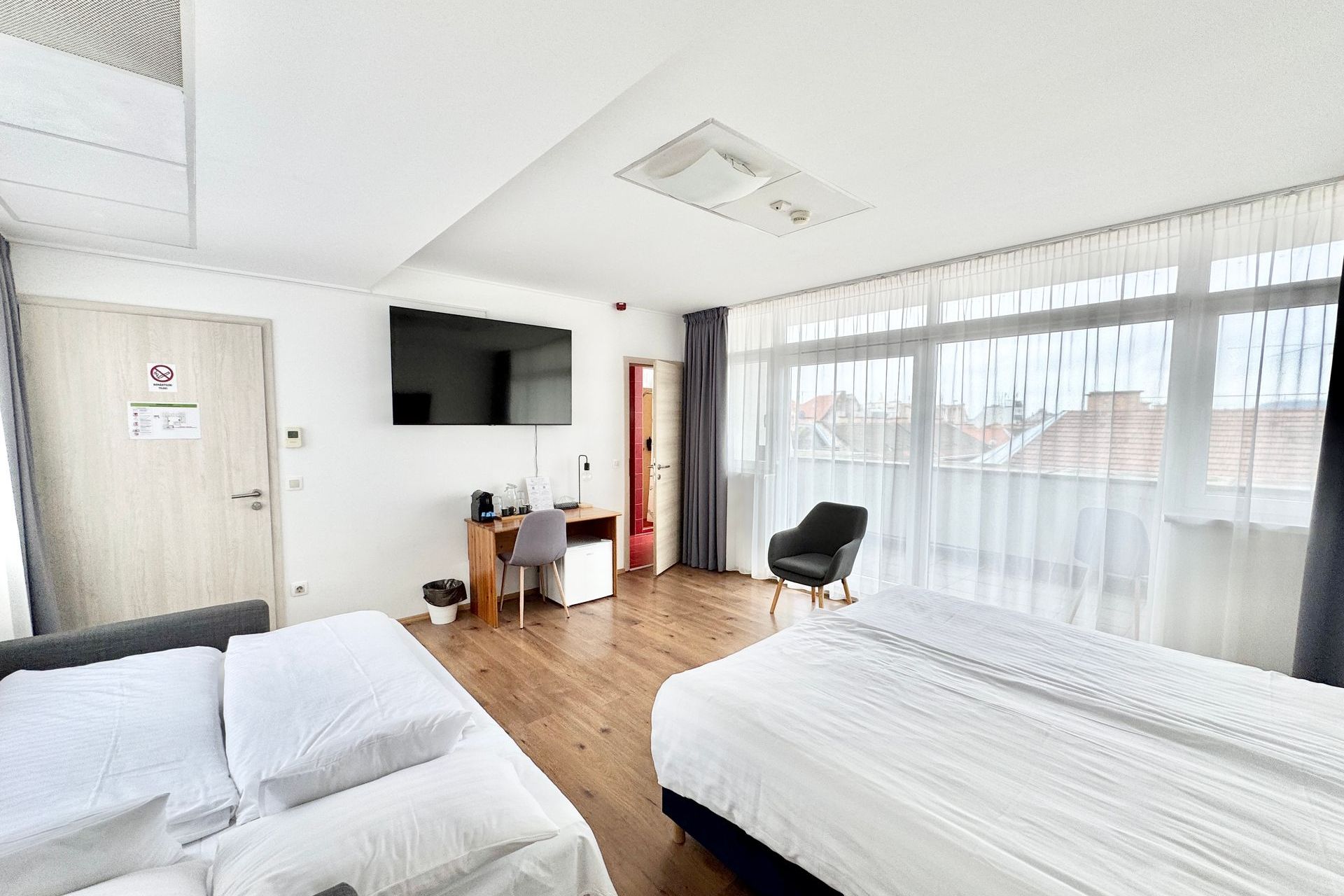 A hotel room with two beds and a flat screen tv.