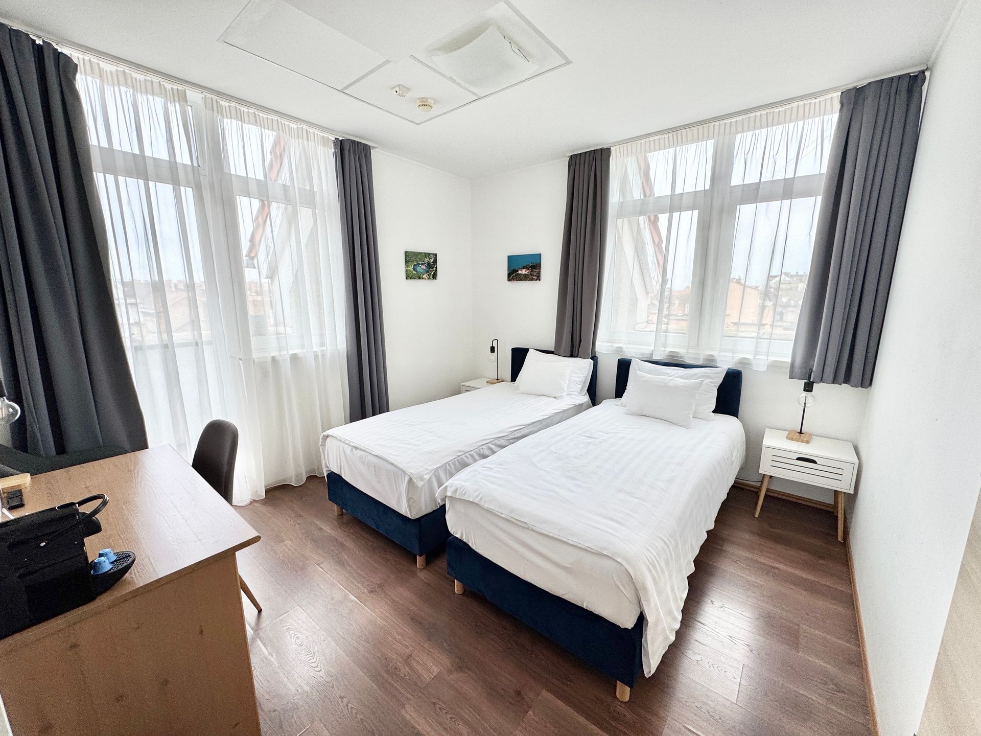 A hotel room with two beds and a desk.