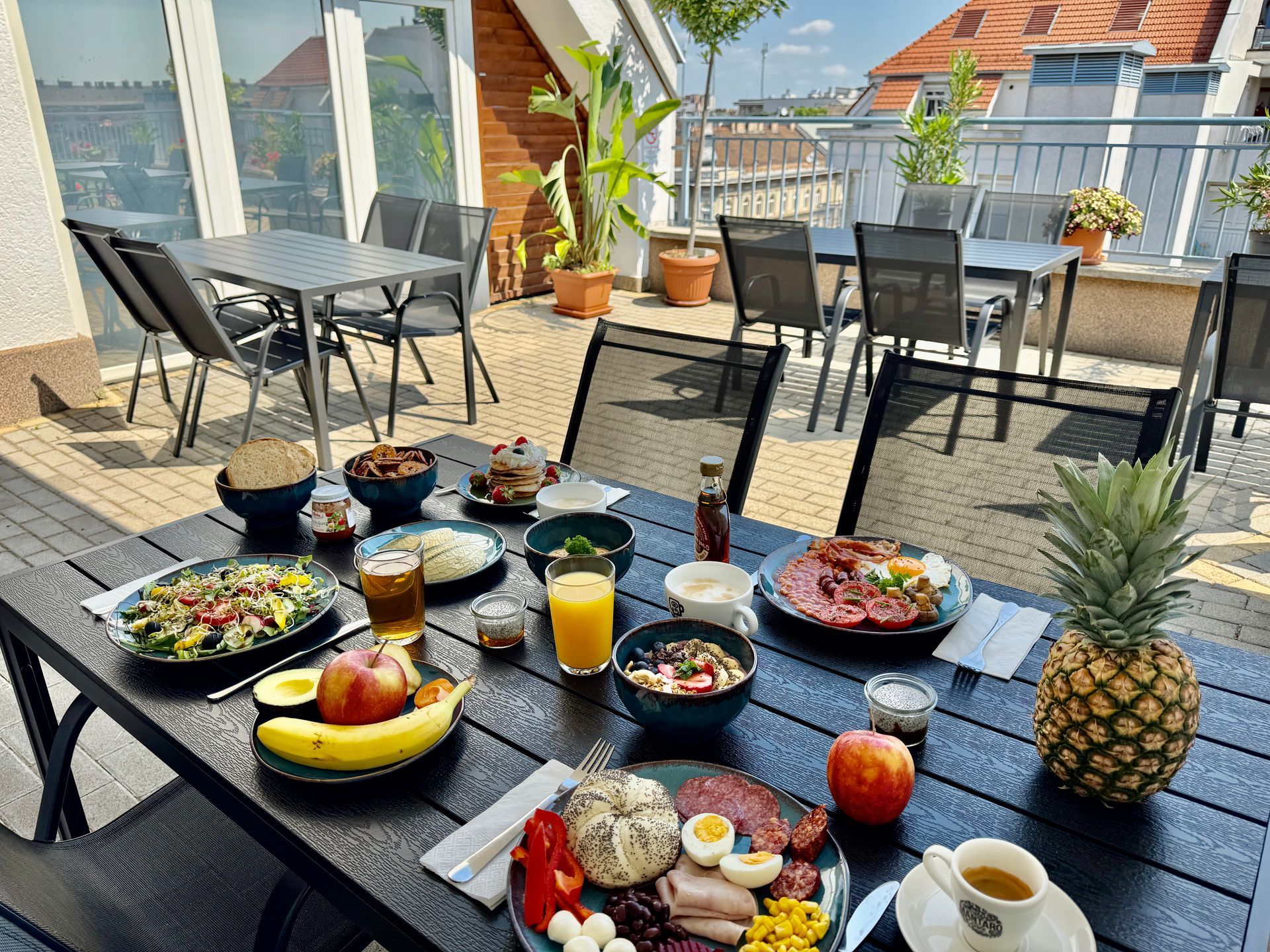 A table topped with plates of food and a pineapple on a patio.