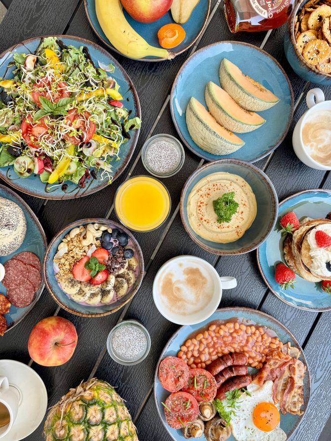 A table topped with plates of food and drinks.