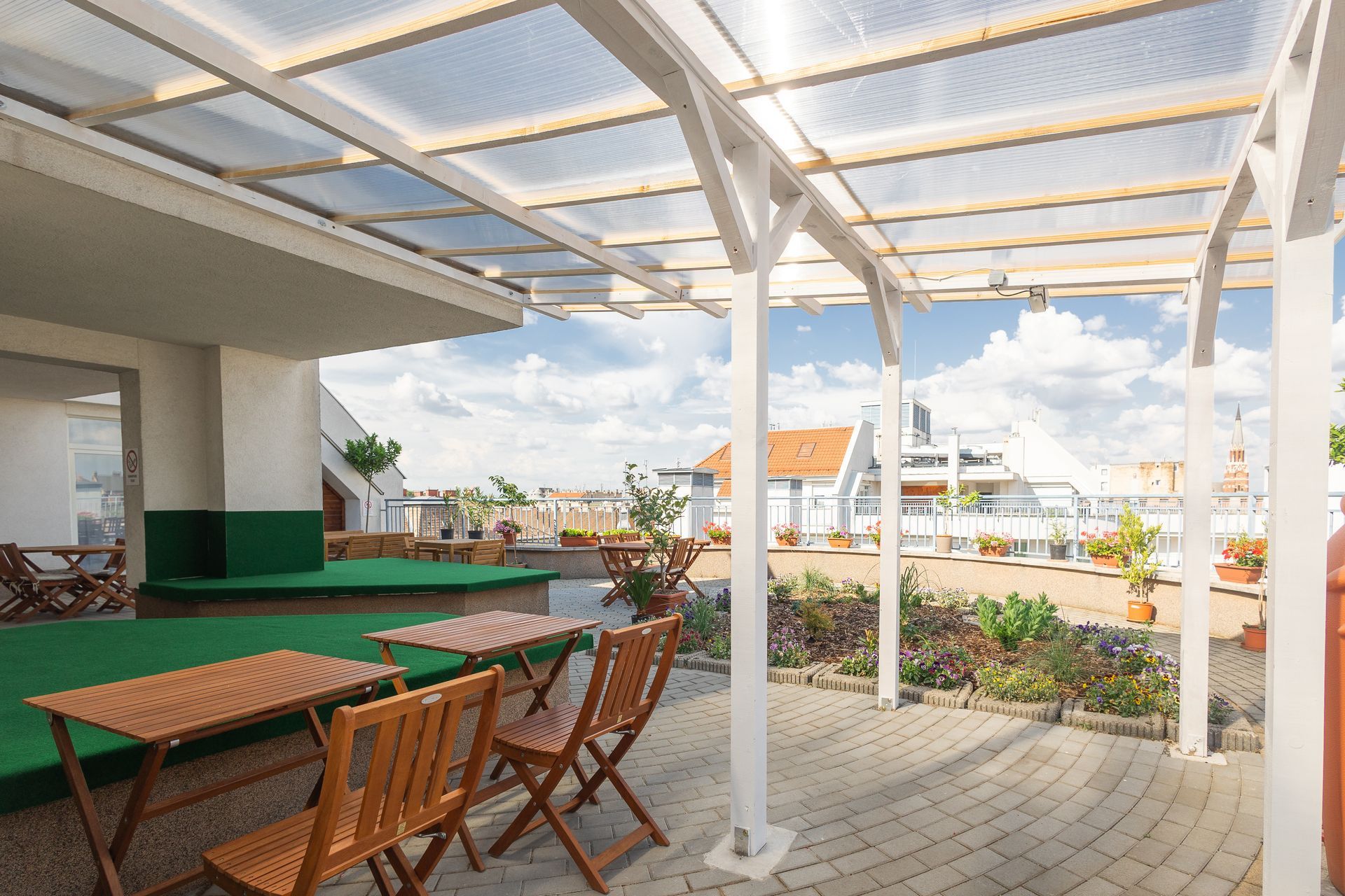 A patio with tables and chairs under a clear roof