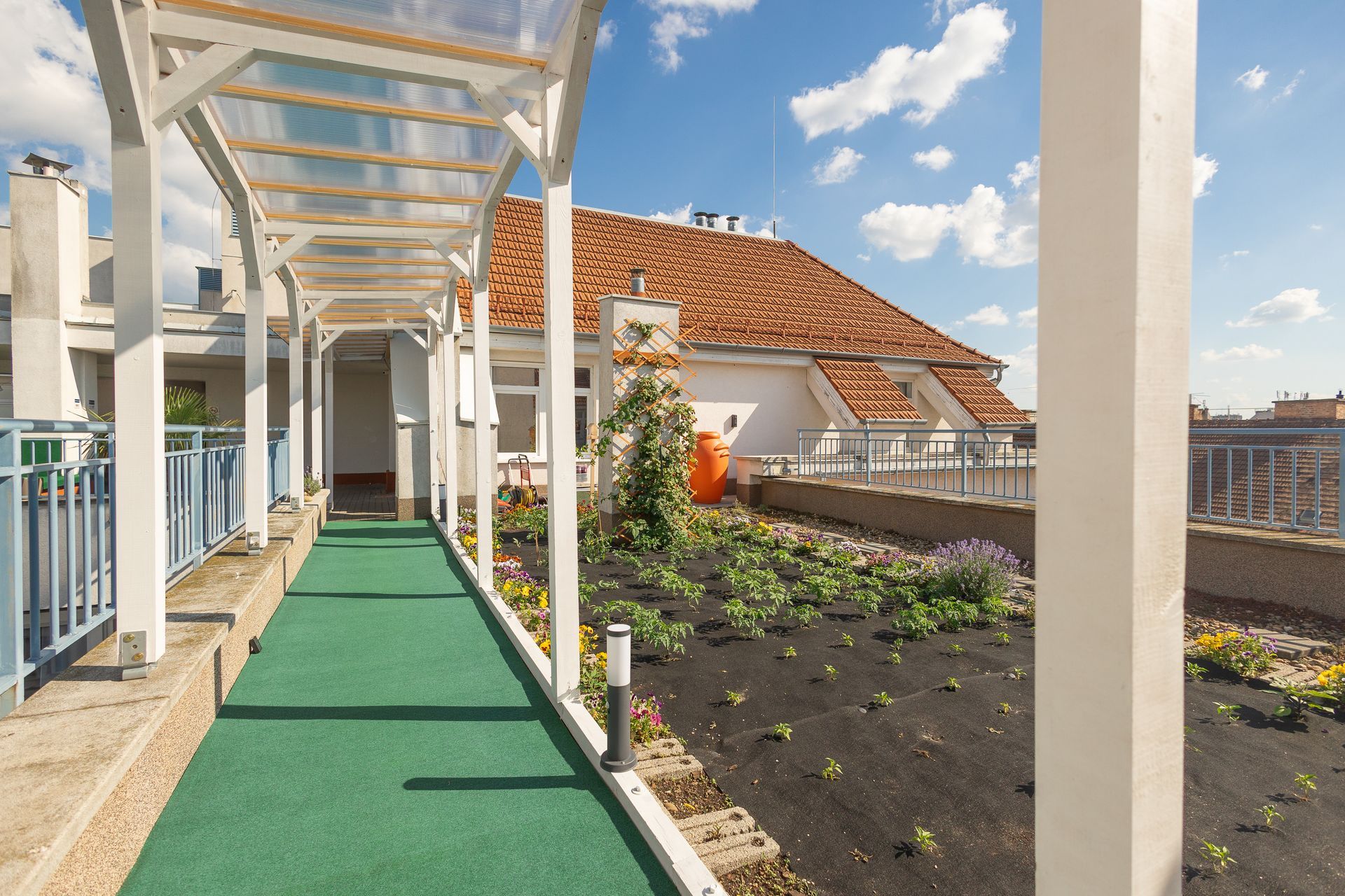 A green walkway leading to a rooftop garden