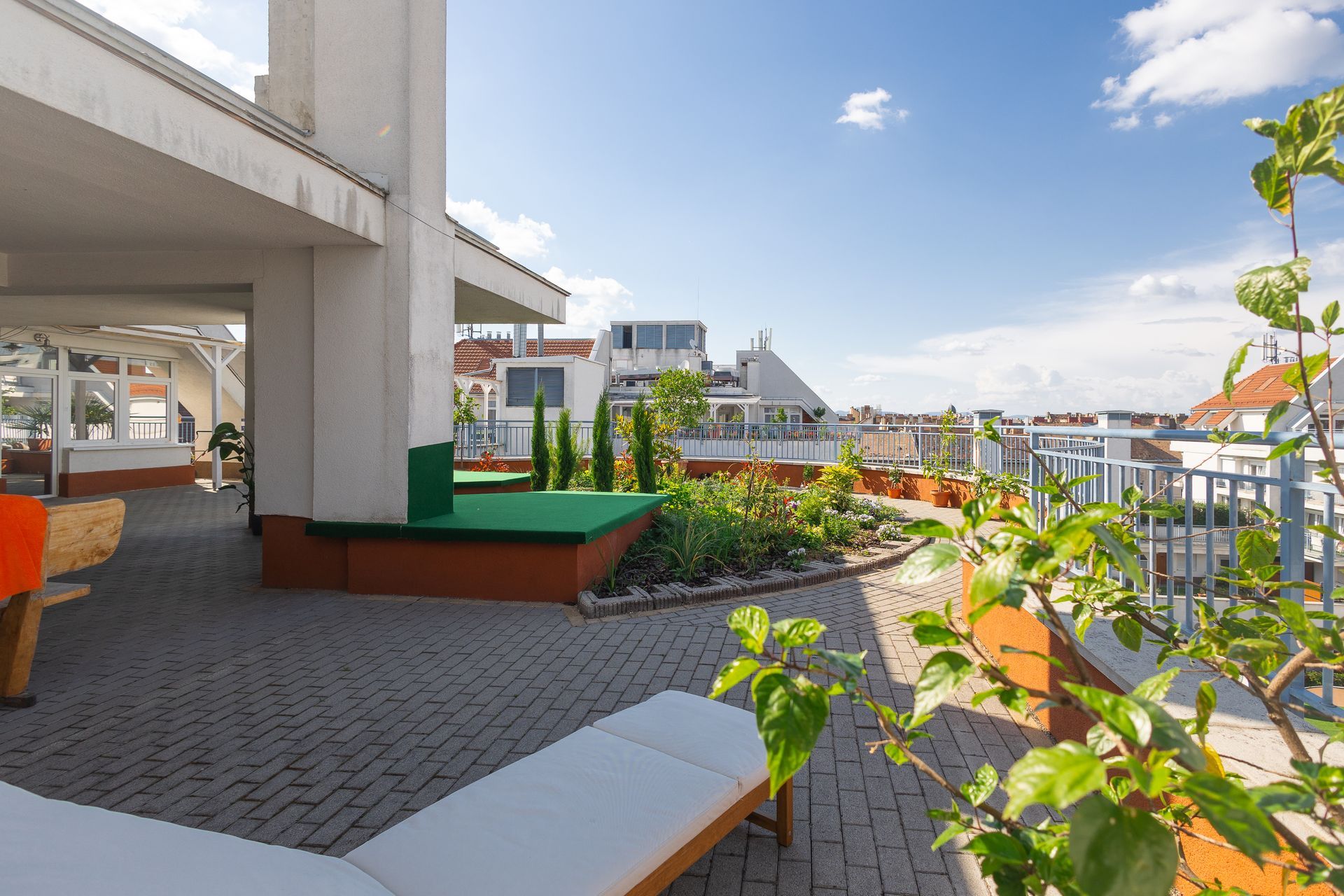 There is a rooftop garden with a couch and chairs on it.