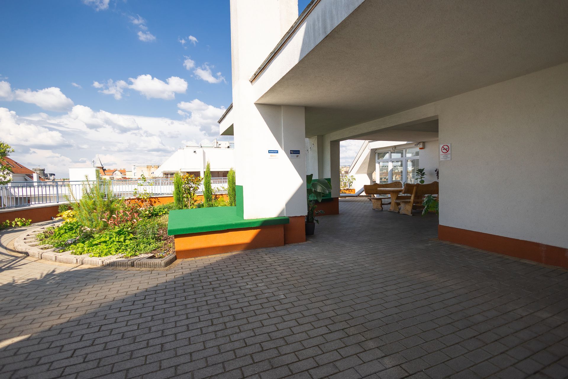 A white building with a green bench in front of it