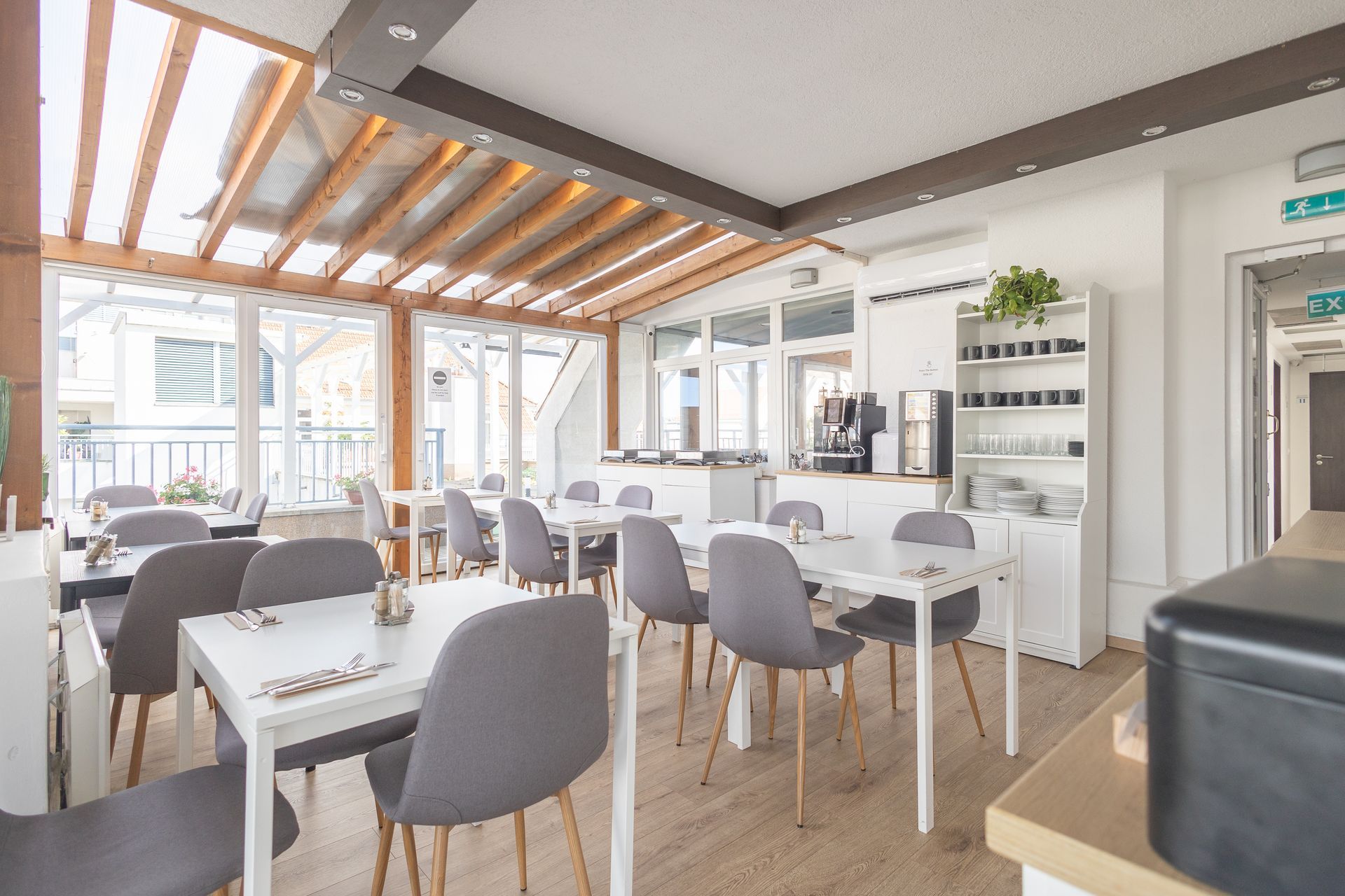 A restaurant with tables and chairs and a lot of windows.