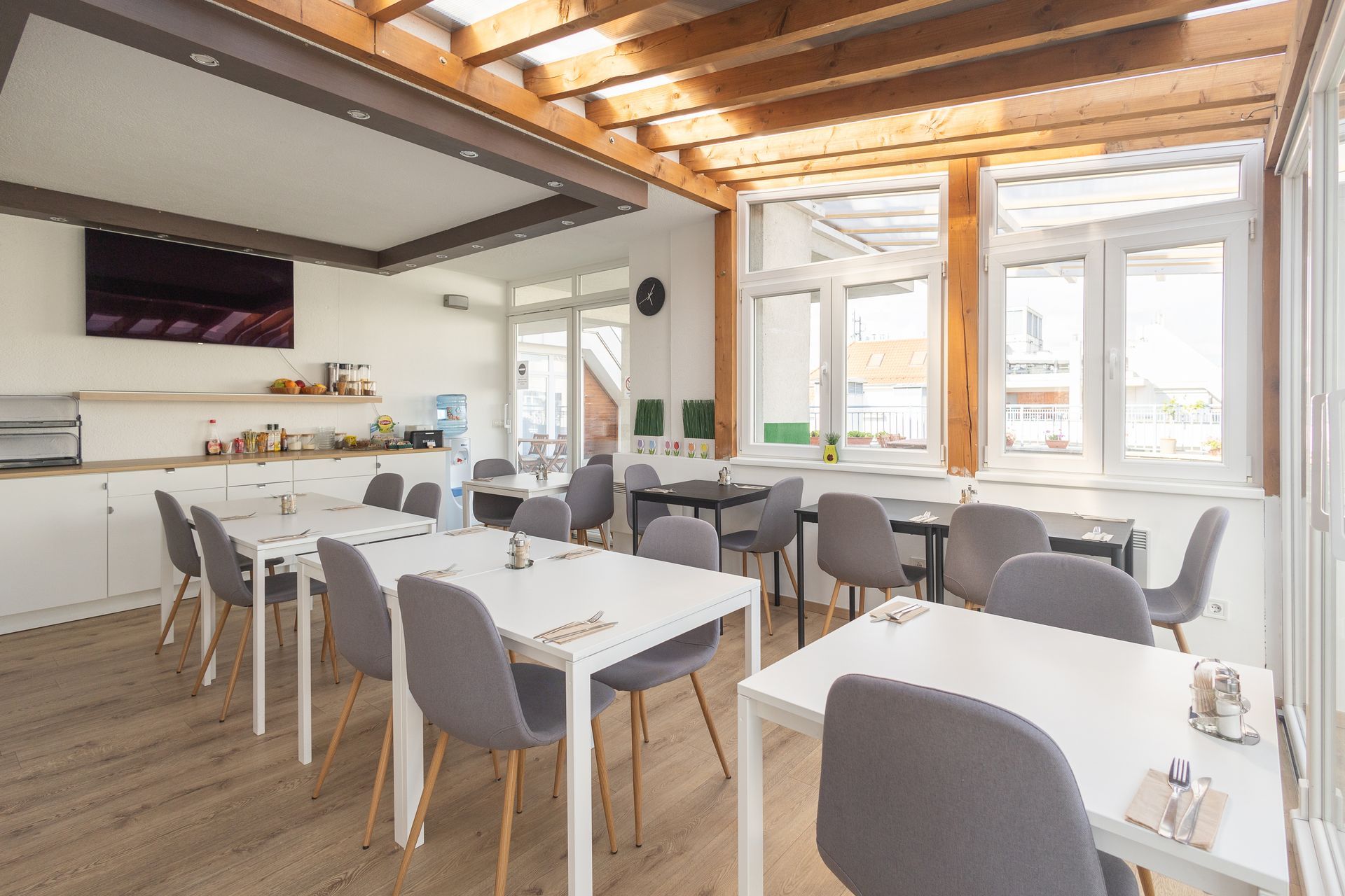 There are many tables and chairs in the room.